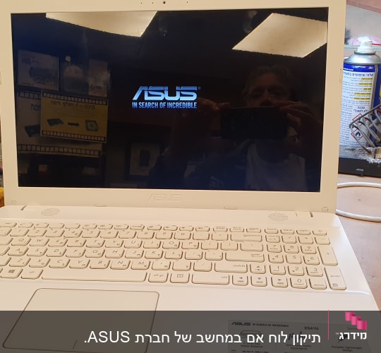 מחשב נייד ASUS על שולחן עבודה עם כלים